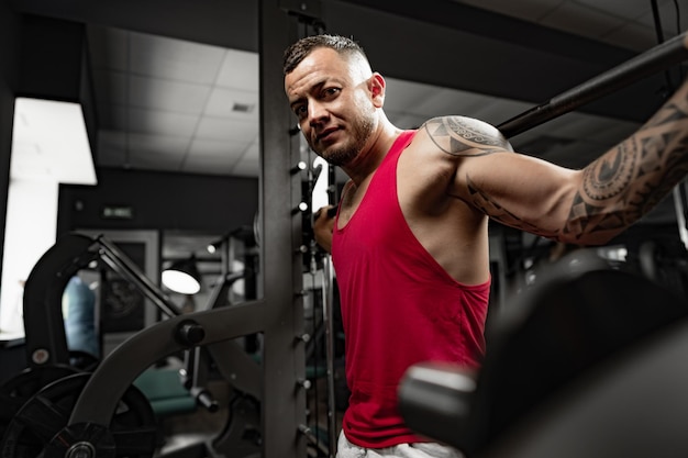 Portrait of man bodybuilder in red shirt in gym