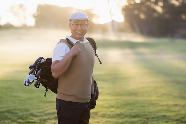 Portrait of man carrying golf bag