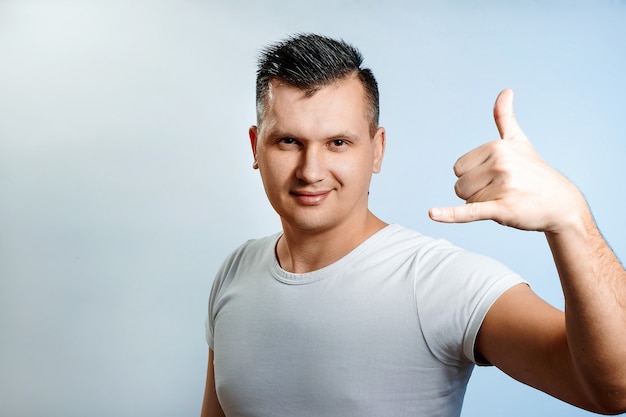 Portrait of a man close-up, Showing a hand to call me, dial on the phone. 