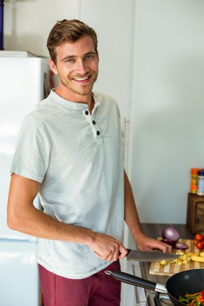 Photo portrait of man cutting vegetables in kitchen at home