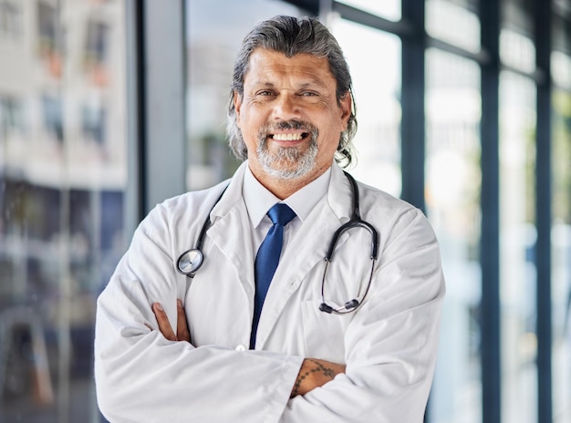 portrait man and doctor with arms crossed smile and surgeon with confidence career and medicine face mature person and medical professional in a hospital healthcare expert and happy employee