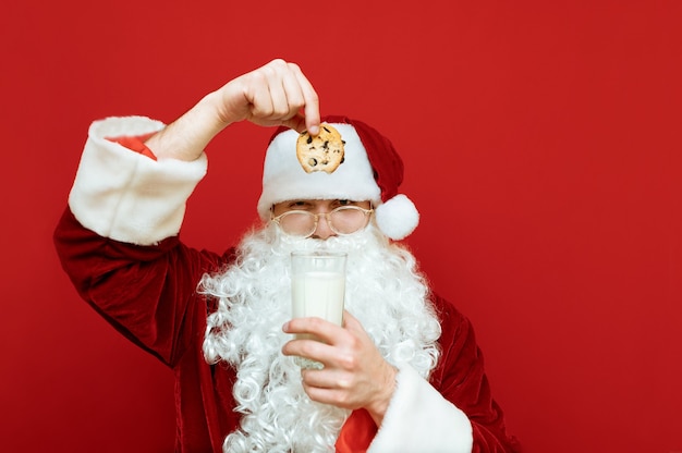 Ritratto uomo vestito da babbo natale mangiare gocce di cioccolato