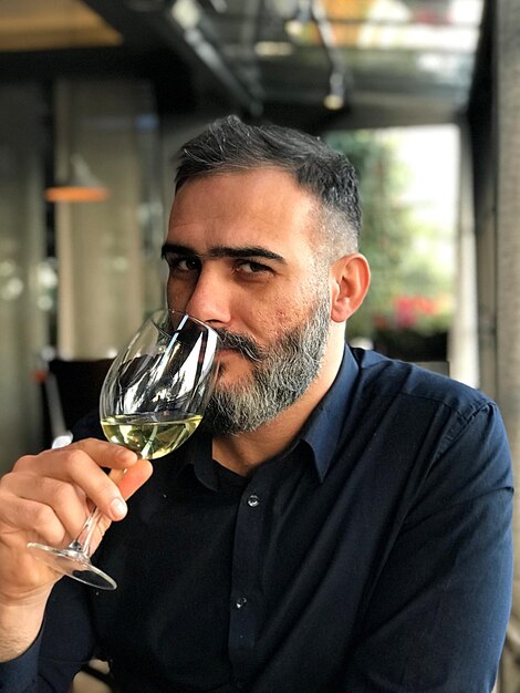 Photo portrait of man drinking wine at restaurant