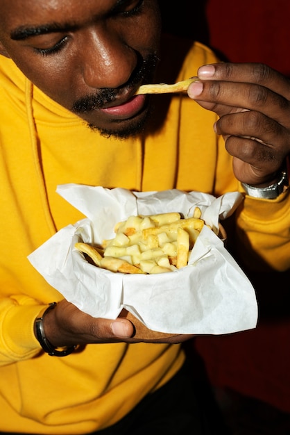 Portrait of man eating a delicious dish of poutine