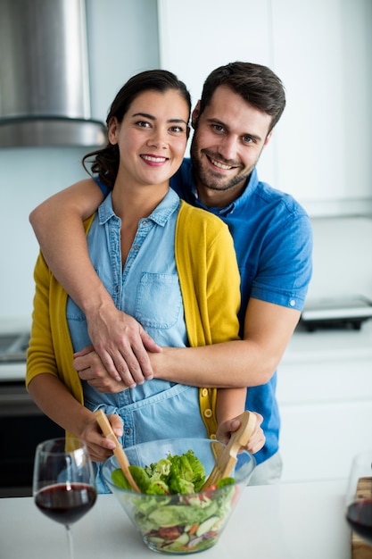 Portrait of man embracing woman in the kitchen at home