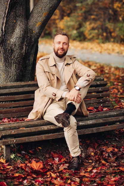 Portrait of a man in the forest with autumn leaves behind him