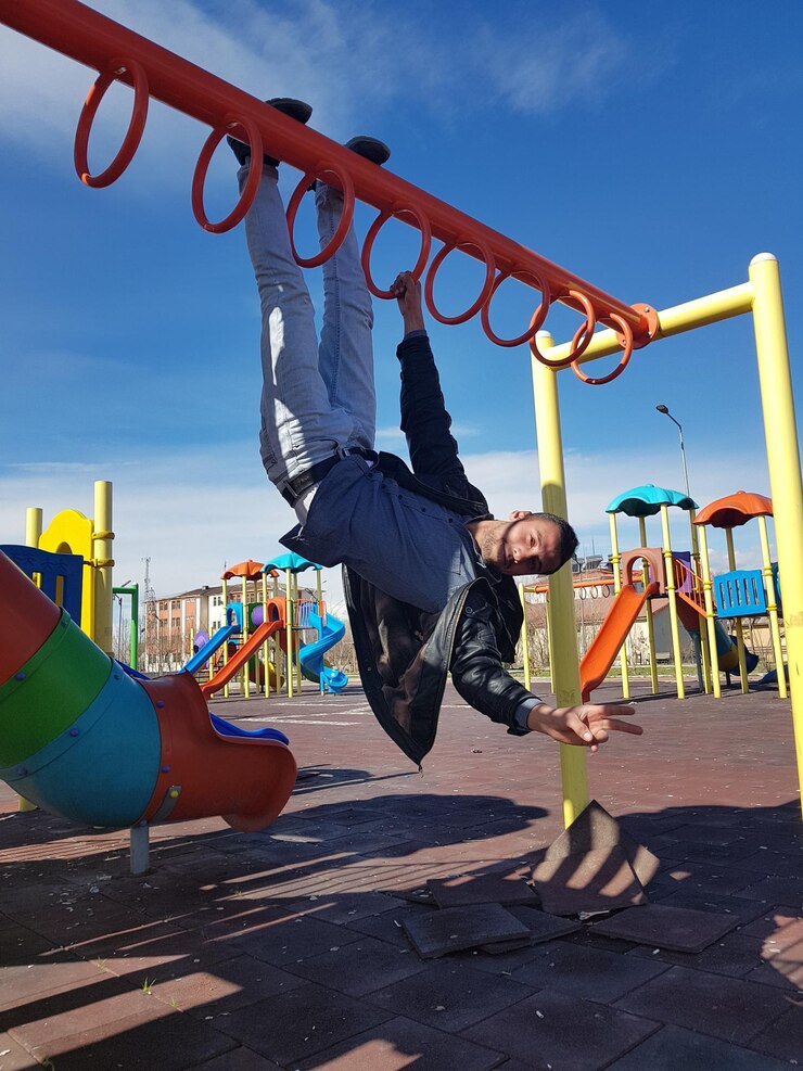 Photo portrait of man hanging on monkey bars at playground