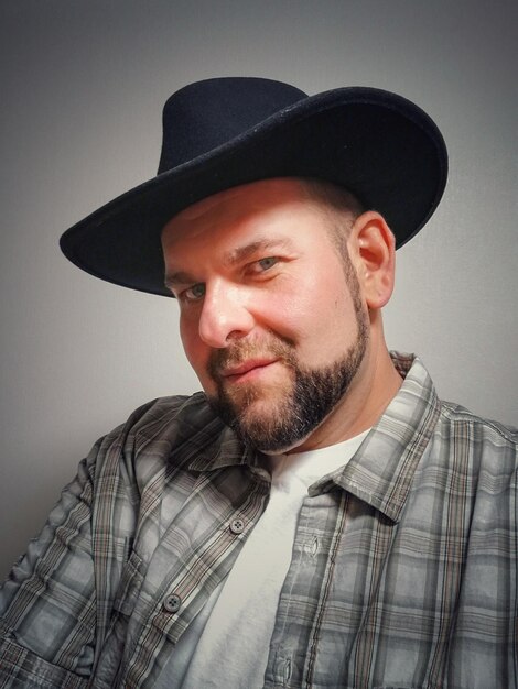 Photo portrait of man in hat against gray background