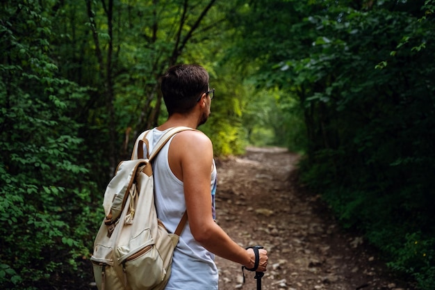 Портрет мужчины-туриста, идущего по тропе в лесу