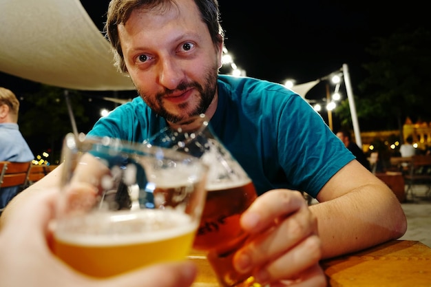 Photo portrait of man holding beer at table