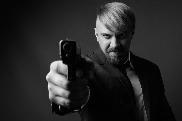 Photo portrait of man holding camera over black background