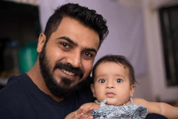 Photo portrait of man holding cute girl at home