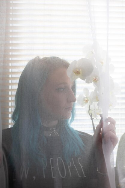 Photo portrait of man holding flower in glass window