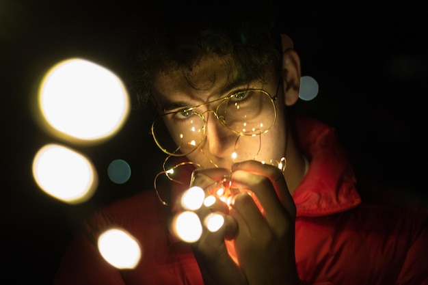 Photo portrait of man holding illuminated lights