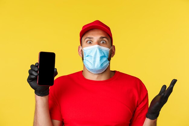 Portrait of man holding smart phone against yellow background