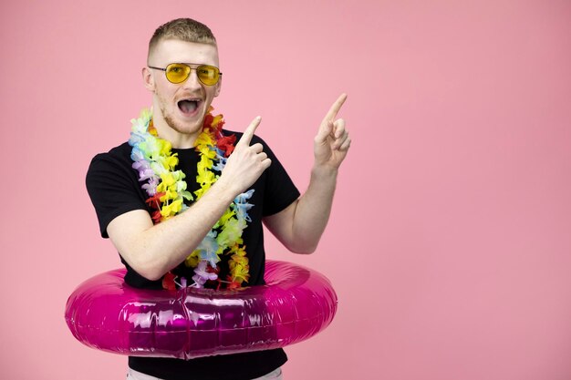 Portrait of man holding umbrella against pink background