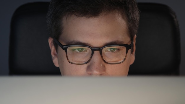 Portrait of man at home office working looking at the screen at\
night