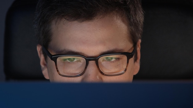 Portrait of man at home office working looking at the screen at
night