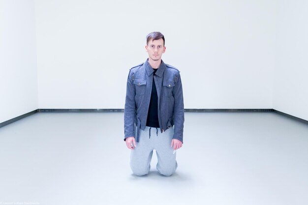 Photo portrait of man kneeling in room