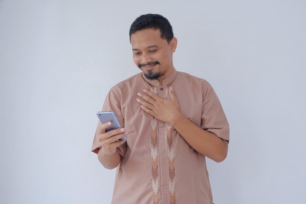 Portrait of man looking his phone with flattered gesture