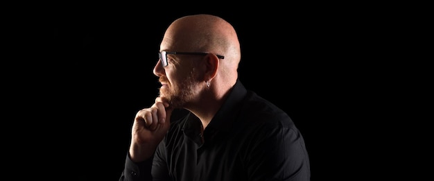 Portrait of a man in low key, smiling and looking side with eyewear