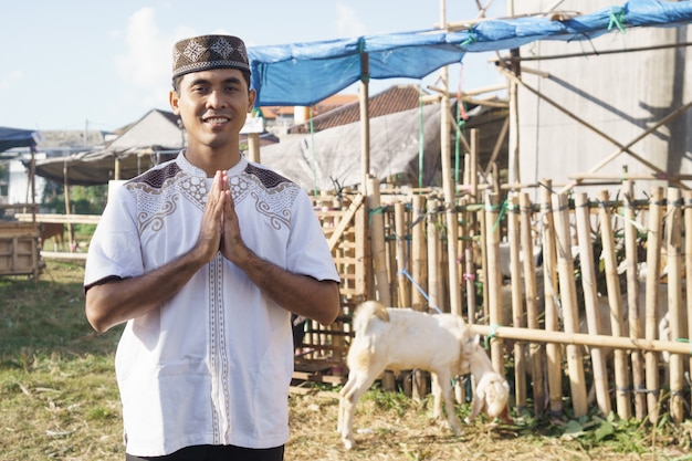 Portrait of a man muslim standing in front of goat farm. eid adha sacrifice concept