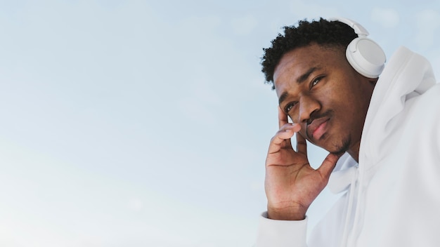 Portrait of man outside with headphones and copy space