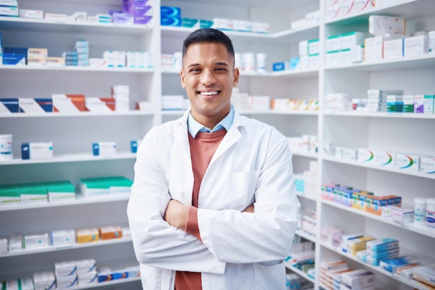 Photo portrait man and pharmacist with arms crossed in pharmacy or drugstore healthcare wellness and happy proud and confident smile of male medical professional expert or doctor from canada in shop