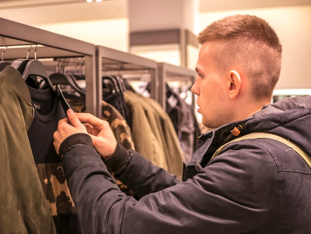 Portrait of man picking up clothes in the store 