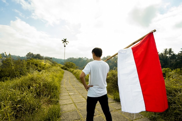 Portrait of a man proudly holding indonesia flag