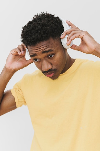 Photo portrait of man putting on headphones