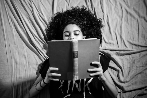 Photo portrait of man reading book on bed