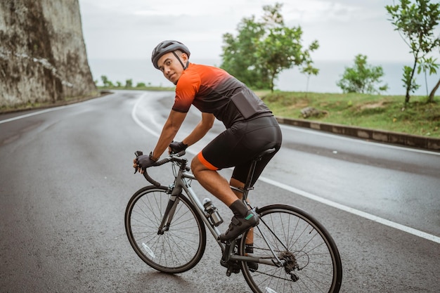 Foto ritratto di un uomo in bicicletta su una strada