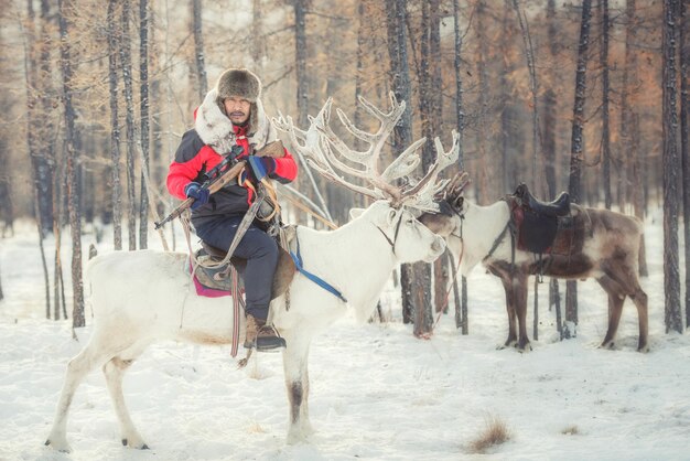 Foto ritratto di un uomo che cavalca le renne in inverno