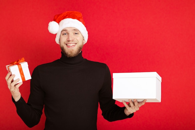 Portrait of a man in a Santa Claus hat with gift boxes