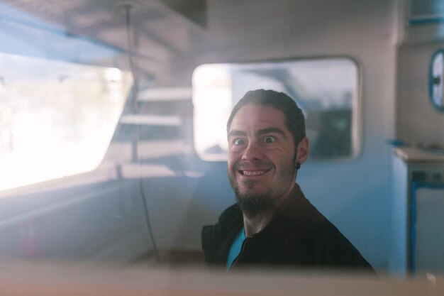 portrait of man seen through window of camper trailer