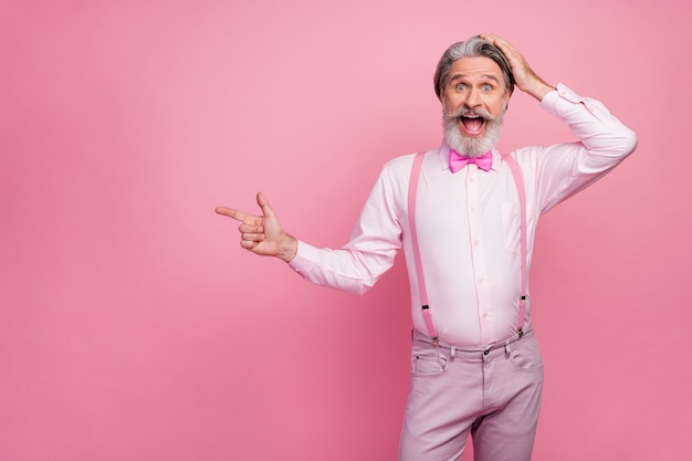 Portrait of man showing advert choose on pink wall