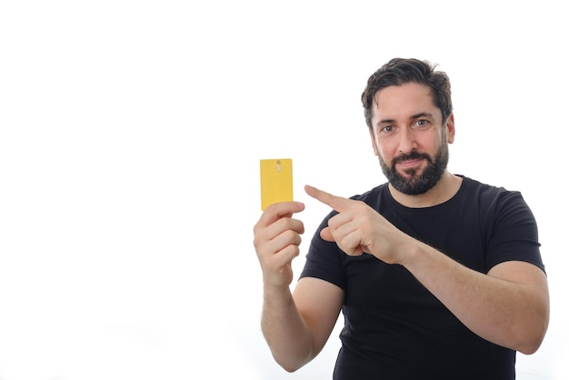 Portrait of a man showing and pointing with finger at credit card while standing on an isolated background. Financial and payment concept.