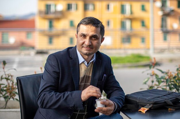 Photo portrait of man sitting in city