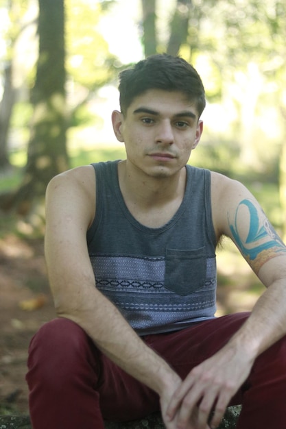 Photo portrait of man sitting at park