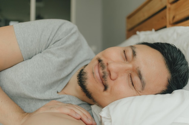 Photo portrait of man sleeping on bed