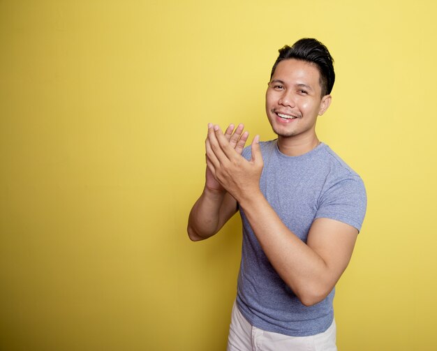 Portrait man smile expression very spirit with applause hand isolated on a yellow color background