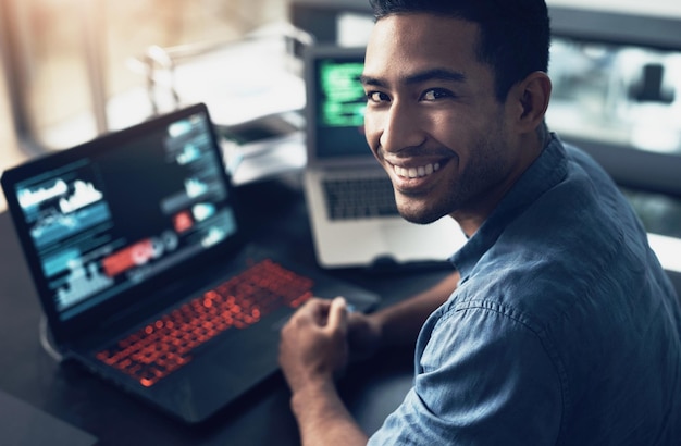 portrait man and smile of programmer on computer in office workplace at night it face and male coder or person programming coding and writing for software development or information technology