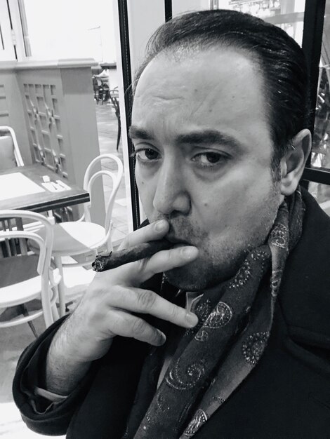 Foto ritratto di un uomo che fuma un sigaro