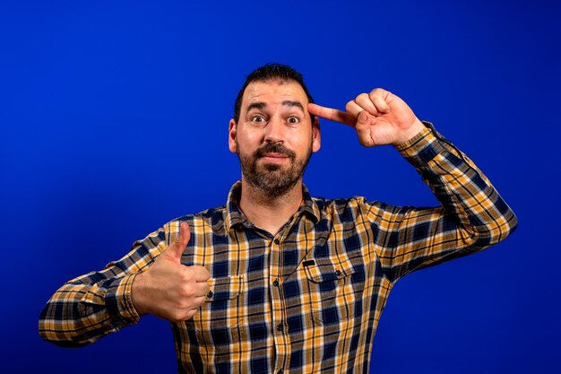 Portrait of man standing against blue background