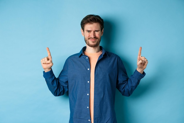 Portrait of man standing against blue background