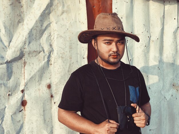 Photo portrait of man standing against fence