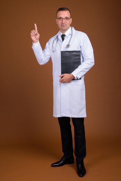 Portrait of man standing against gray background