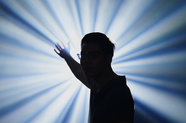 Photo portrait of man standing against light beams