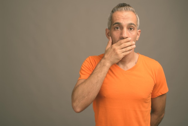 Portrait of man standing against orange background